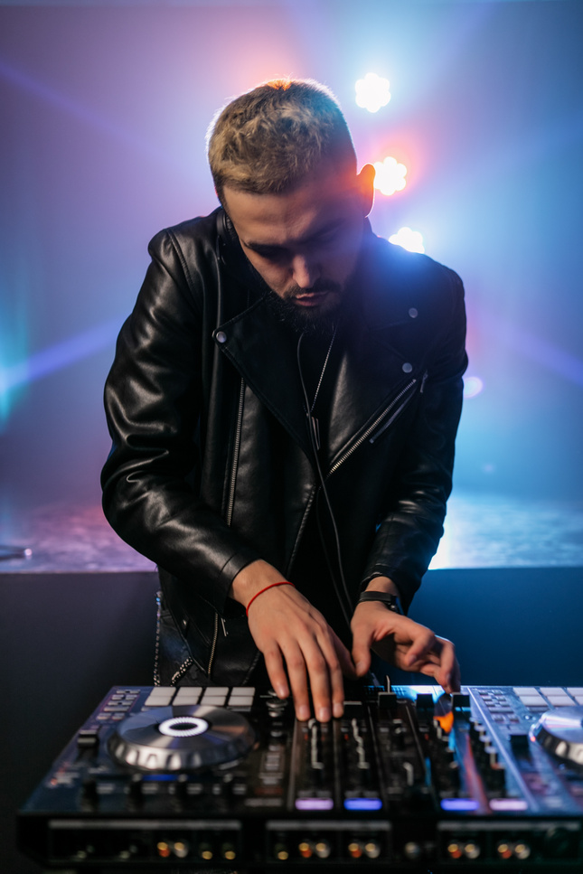 Man Wearing Black Leather Jacket Using DJ Mixer