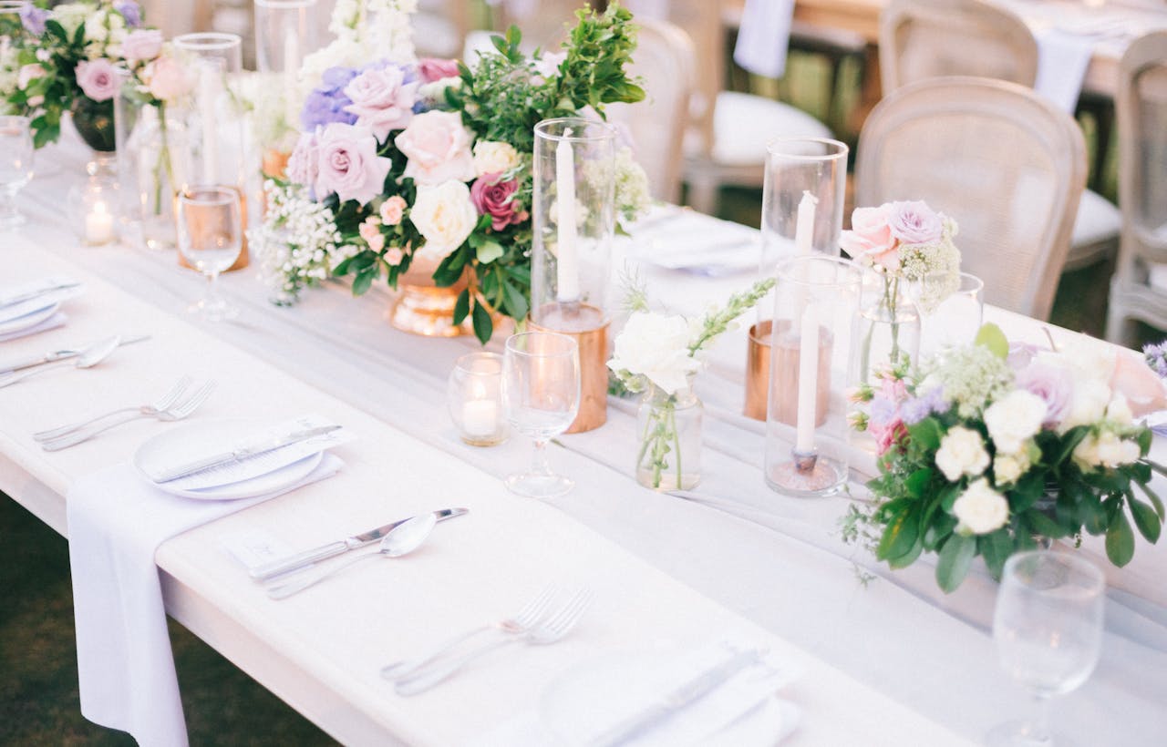 A beautifully arranged wedding table with floral centerpiece and candles.